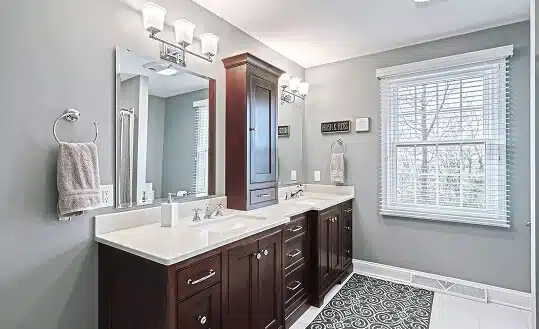 Modern bathroom renovation by a professional kitchen and bathroom remodeler TradeMark Construction LLC in Baltimore, MD, featuring a dark wood double vanity and custom gray wall finishes.