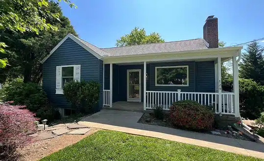 Exterior view of a charming blue home featuring professional remodeling work by a top-rated kitchen remodeler TradeMark Construction LLC in Baltimore, MD.