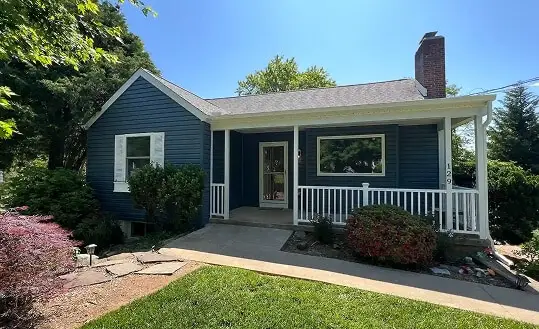 Exterior view of a charming blue home featuring professional remodeling work by a top-rated kitchen remodeler TradeMark Construction LLC in Baltimore, MD.