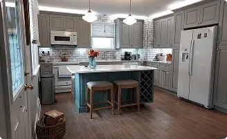 Modern kitchen remodeling in Baltimore, MD featuring gray shaker cabinets, a white subway tile backsplash, and a custom teal island with built-in wine storage.