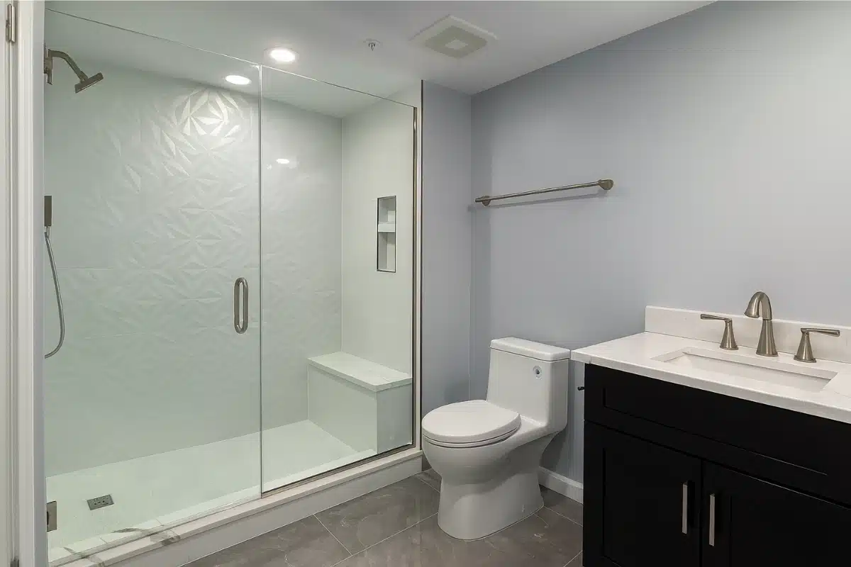Spa-style bathroom remodeling in Baltimore, MD featuring a modern freestanding tub, marble-look tile, and custom vanity shelving for a luxury upgrade.