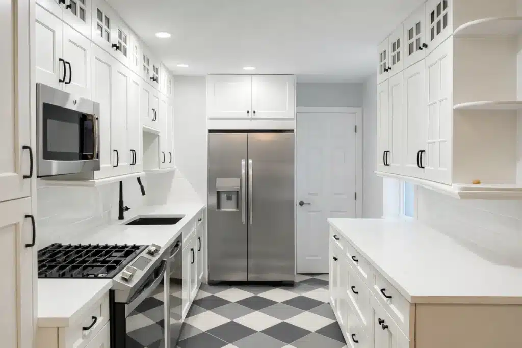 Bright white kitchen remodeling in Baltimore, MD showcasing a galley-style layout with quartz countertops, modern appliances, and checkered tile floor