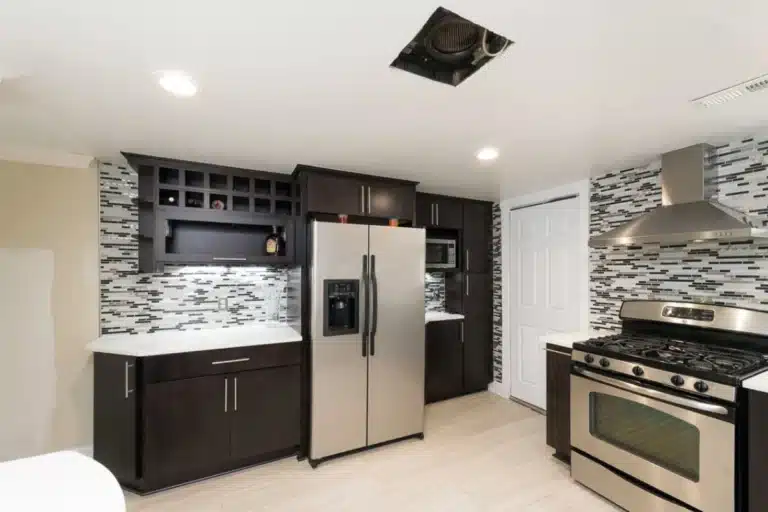 Contemporary kitchen remodeling in Baltimore, MD with dark wood cabinetry, stainless steel appliances, and modern mosaic tile backsplash.