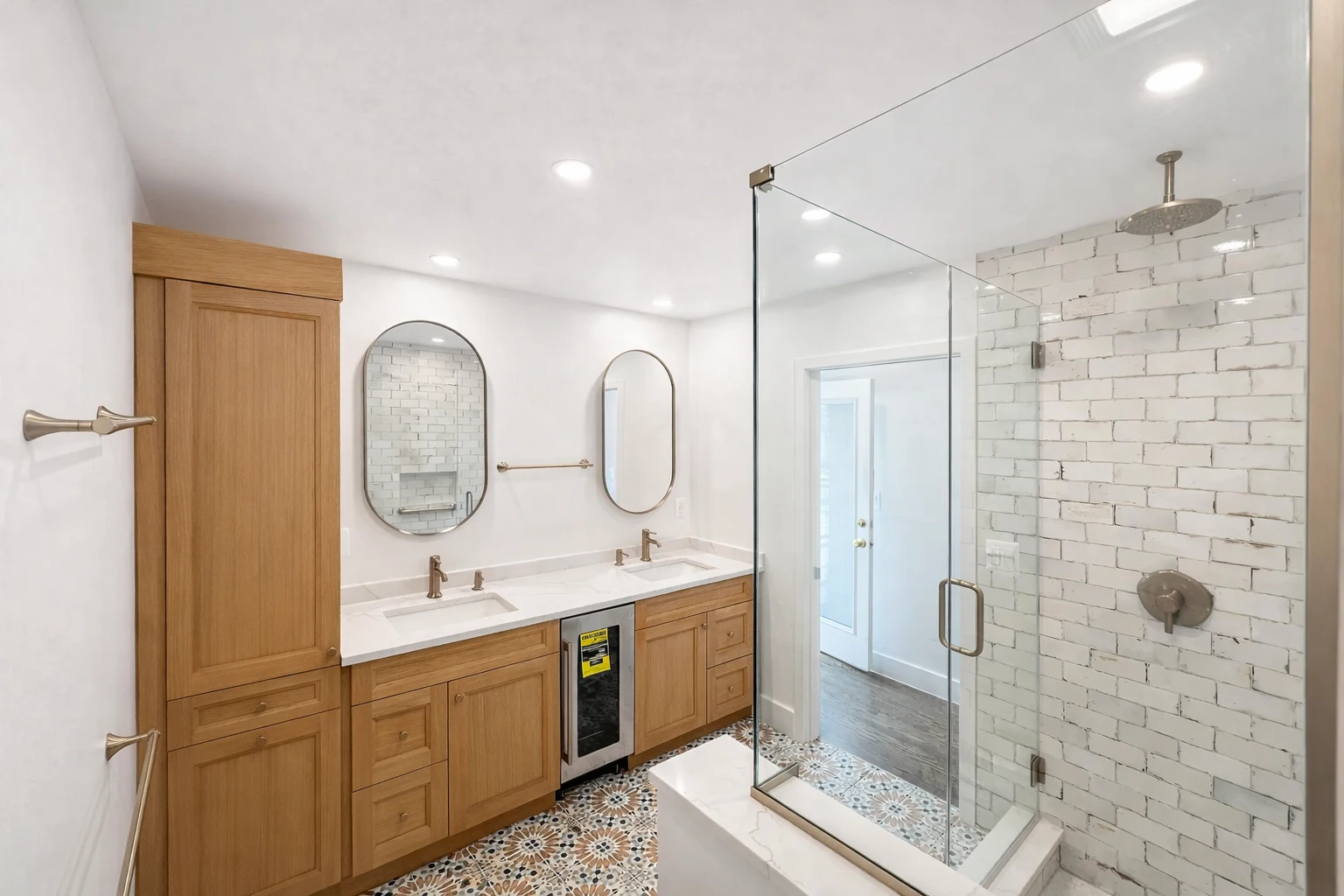 Modern bathroom remodeling project in Baltimore, MD featuring a custom wood vanity, quartz countertops, patterned tile flooring, and a frameless glass