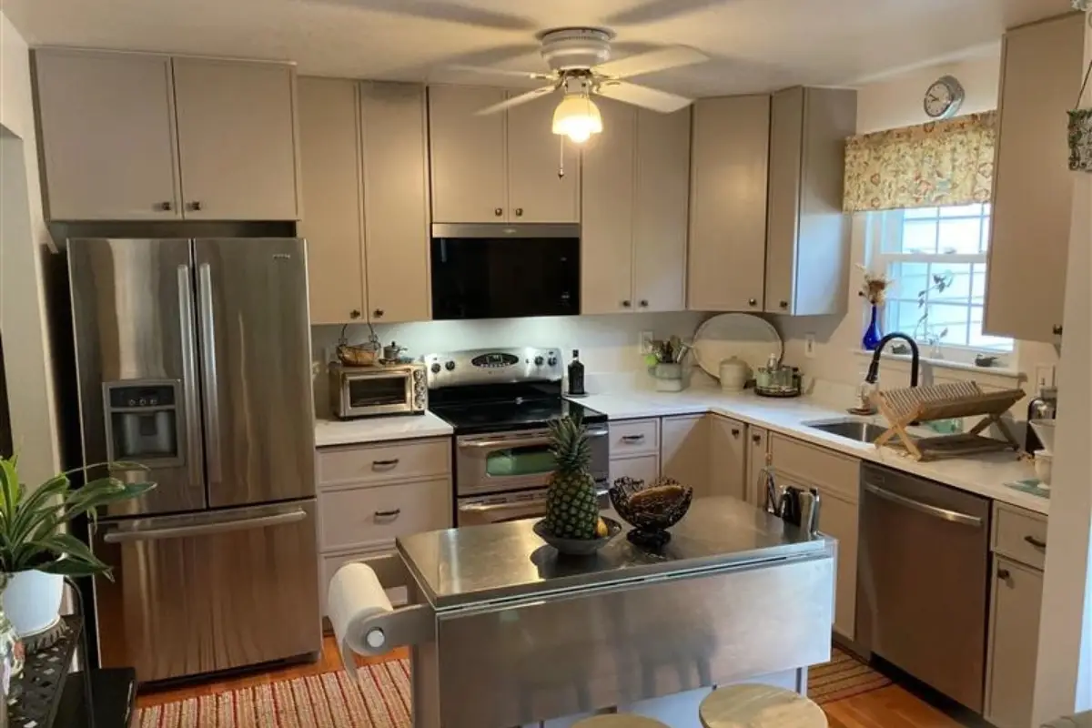 Modern kitchen remodeling project with gray cabinets, stainless steel appliances, and compact island in Cedonia, Baltimore