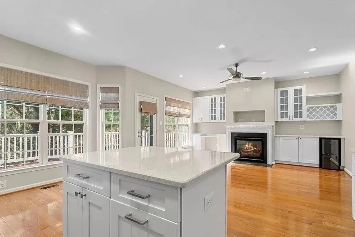 Open-concept kitchen remodeling project with large quartz island, gray cabinets, hardwood floors, and abundant natural light in Mayfield, Baltimore