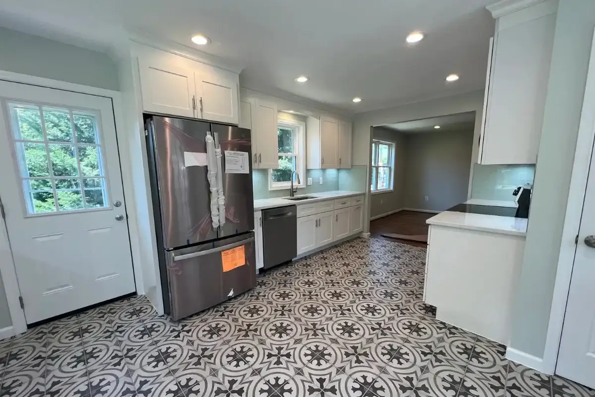 Kitchen remodeling project with white shaker cabinets, patterned tile flooring, quartz countertops, and stainless steel appliances in Berea, Baltimore