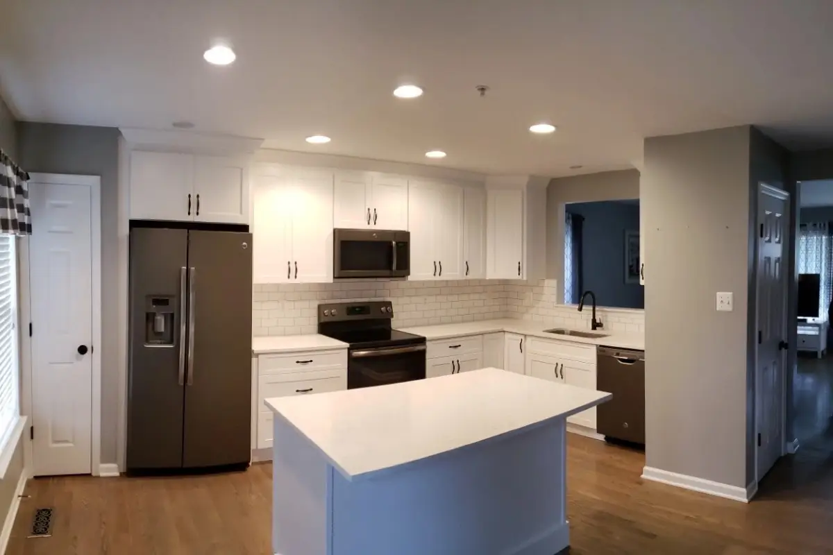 Open-concept kitchen remodeling project in Belair-Parkside, Baltimore featuring white shaker cabinets, a large island, recessed lighting, and stainless steel appliances.