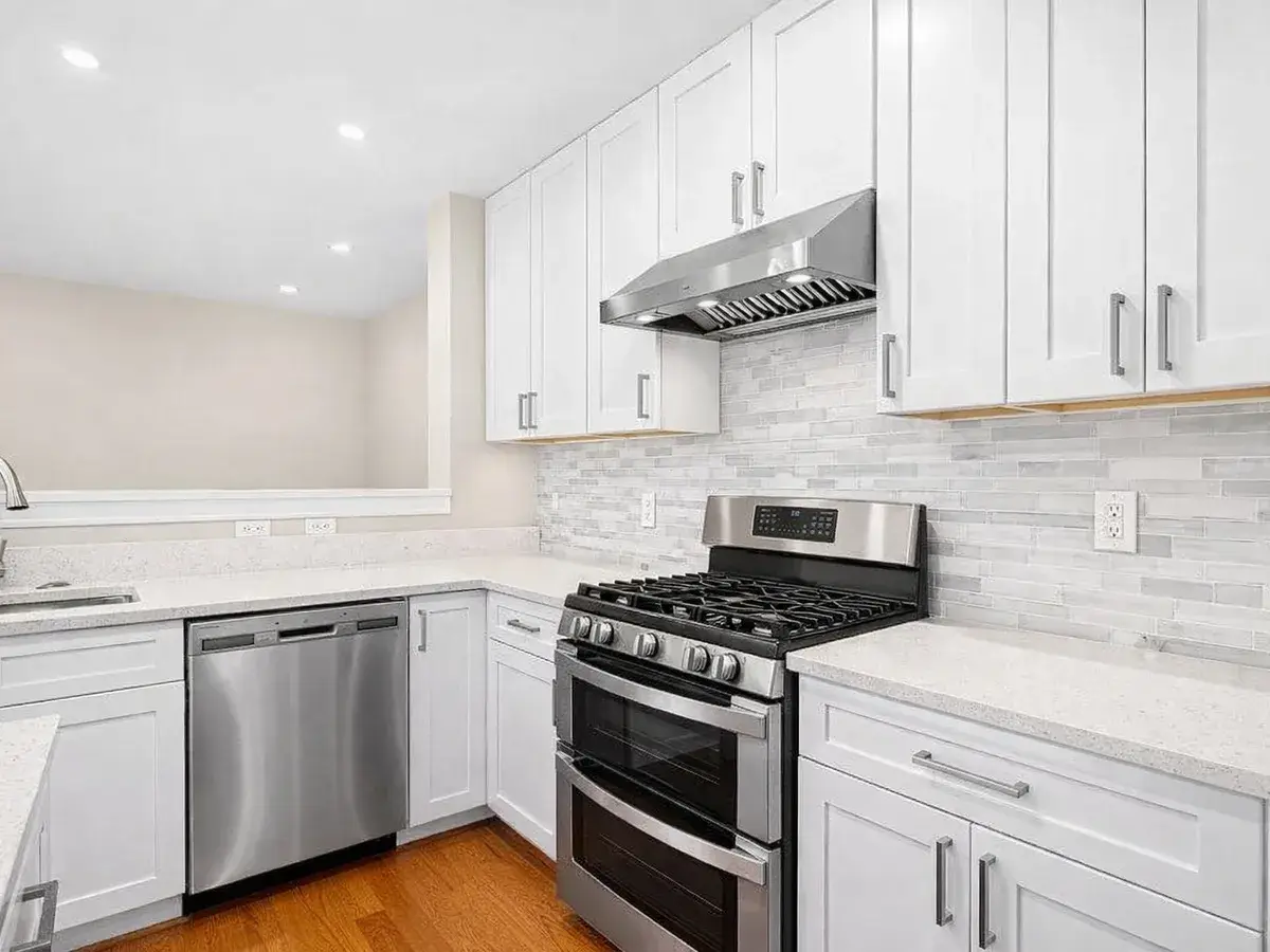 Linear tile backsplash with gas range and quartz countertops in Canton Baltimore kitchen remodel