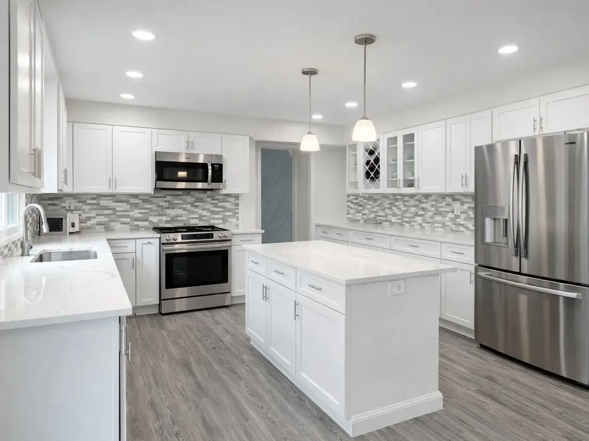 Renovated kitchen with white cabinetry, quartz island, and pendant lighting in Highlandtown Baltimore