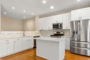 Kitchen remodel with white cabinets and island in an Orangeville Baltimore rowhouse